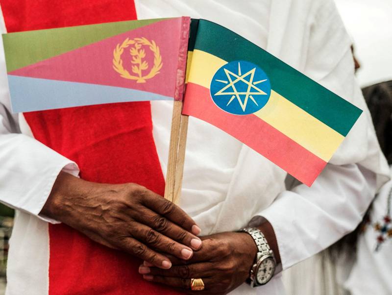 En mann holder det eritreiske (t.v.) og etiopiske flagget mens han venter på at Eritreas president lander i Gondar, nord i Etiopia, under et statsbesøk i november 2018.