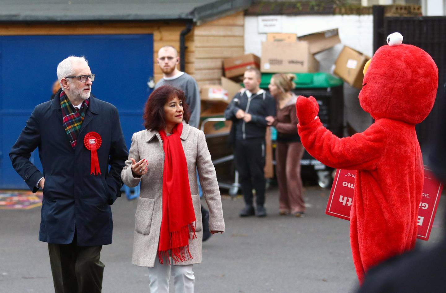 Britain's opposition Labour Party leader Jeremy Corbyn and his wife Laura Alvarez look on as a person in a costume of Sesame Street character Elmo waves, as they arrive at a polling station to vote in the general election in London, Britain, December 12, 2019. REUTERS/Hannah McKay