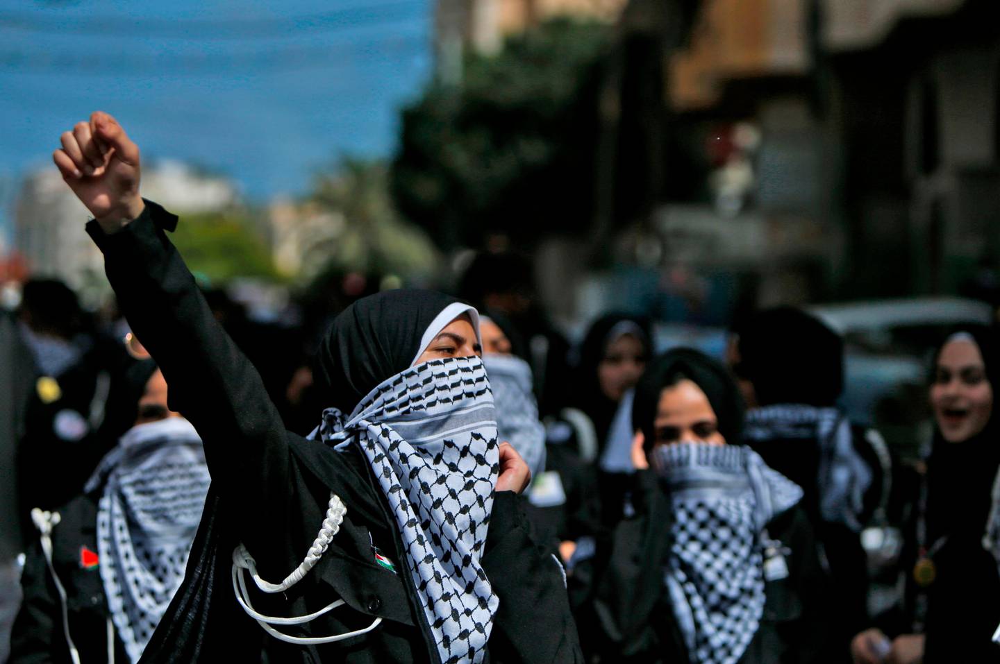 Palestinian youths, using the traditional keffiyeh scarves as masks due to COVID-19, march during a demonstration against Israel's plans to annex parts of the occupied West Bank, in Gaza City on June 22, 2020. - Israel aims to begin a process of annexing West Bank settlements and the Jordan Valley from July 1, as part of a US peace initiative. (Photo by MOHAMMED ABED / AFP)