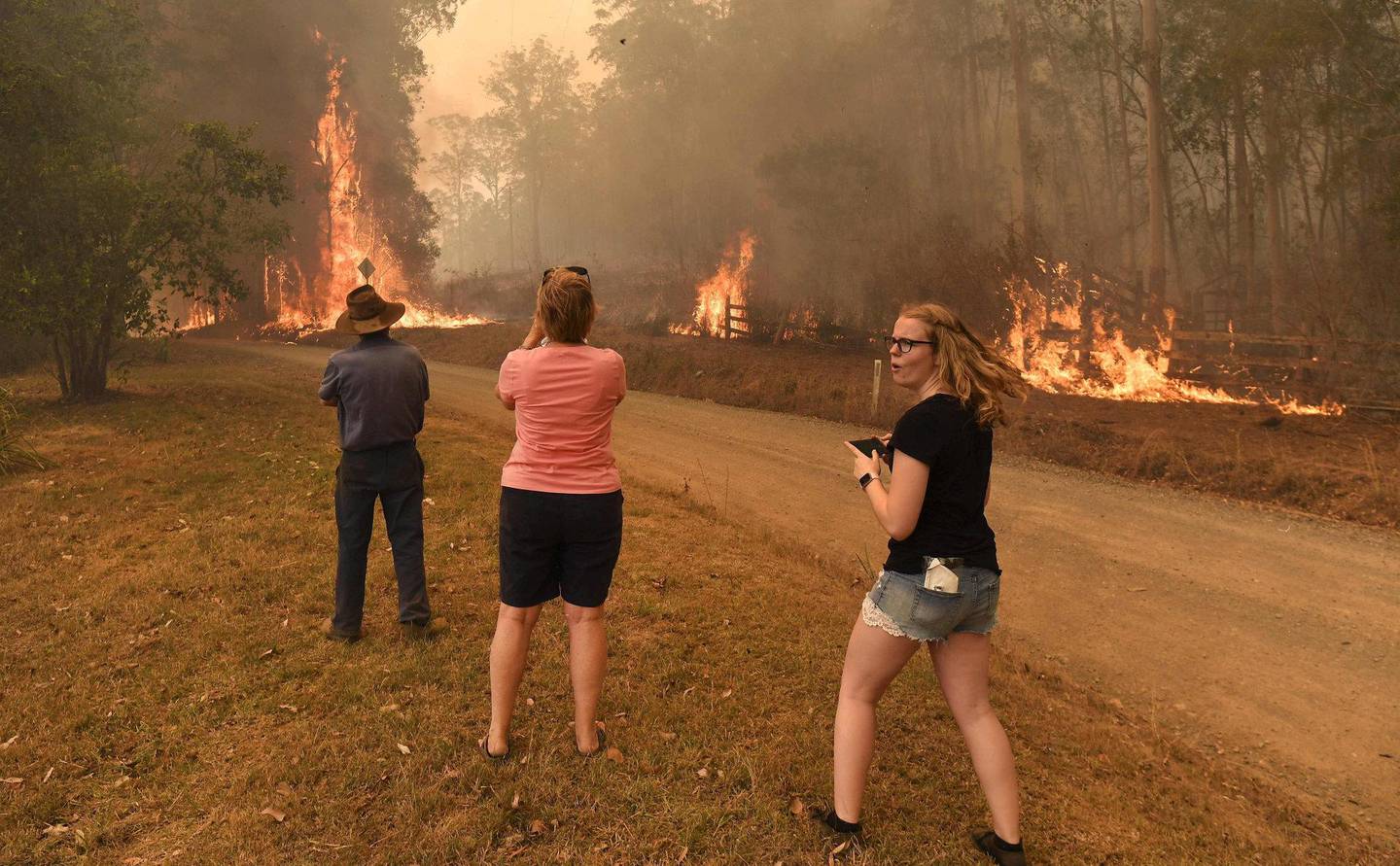 Innbyggere i Nabiac 35 mil nord for Sydney ser på flammene som nærmer seg husene deres. Foto: NTB scanpix