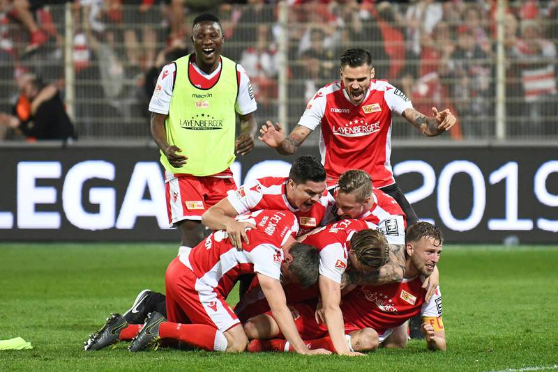 FC Union Berlin players celebrate after the soccer match with VfB Stuttgart in Berlin, Germany, Monday May 27, 2019.  FC Union Berlin secured promotion to the Bundesliga. (Joerg Carstensen/dpa via AP)
