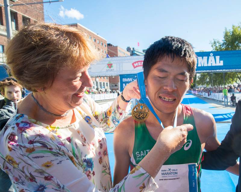 Ordfører Marianne Borgen prøver å gi medalje til Yuki Kawauchi, vinner av Oslo Maraton på 2.15.57.