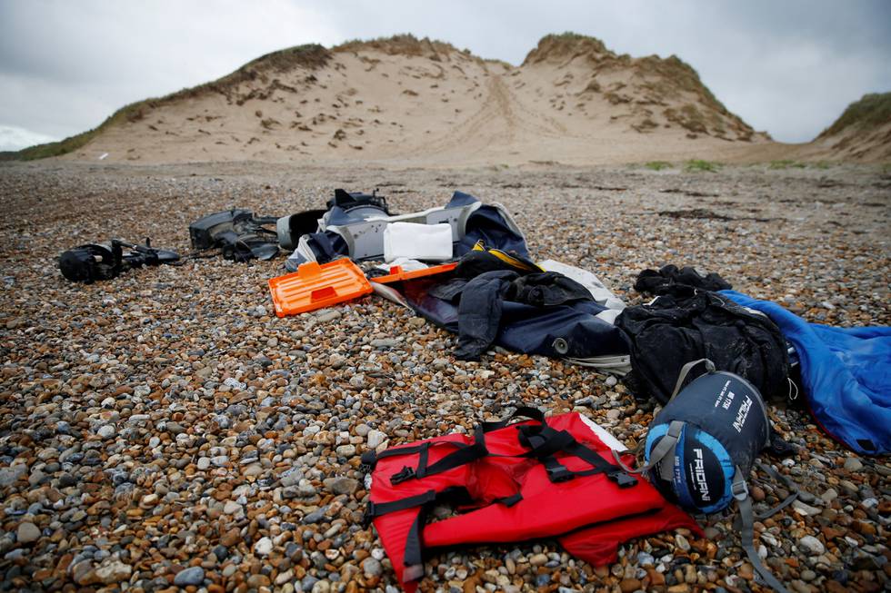 Redningsvest, en ødelagt motorbåt og annet utstyr på en strand i nærheten av Calais i Frankrike.