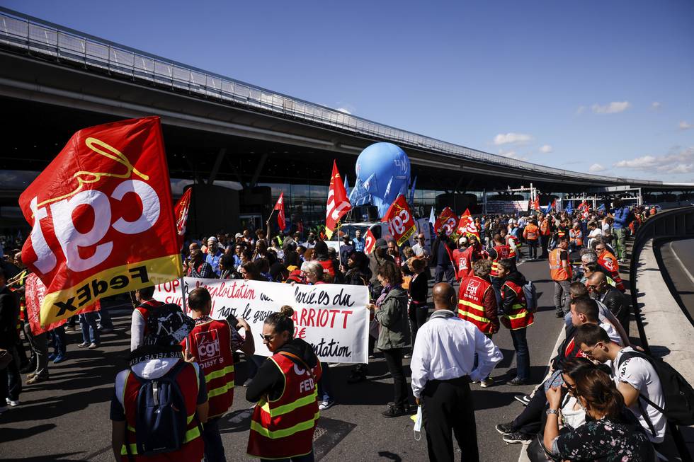 Ansatte streiker utenfor en terminal ved Charles de Gaulle flyplass, nord for den franske hovedstaden Paris. Foto: Thomas Padilla / AP / NTB