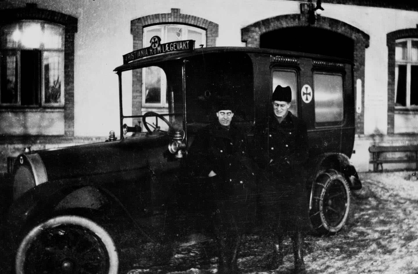 To menn i uniform står foran en sykebil.