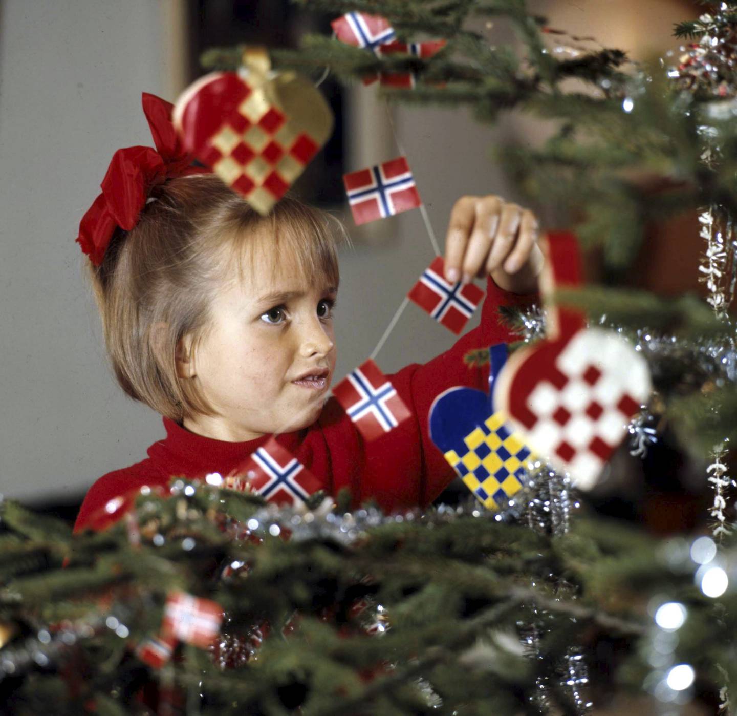  I 1970 var det hjemmeflettede kurver og norske flagg som gjaldt da denne jenta pyntet treet. I dag velger flere en mer moderne stil på juletreet. 