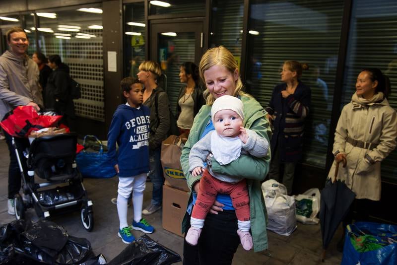 Silje Nysether (30) og datteren Ingeborg Nysether Mjelde (6 måneder) sto nesten helt foran i køen for å gi bort sokker og undertøy til flyktningene på Tøyen onsdag kveld. FOTO: FRØYDIS URBYE 