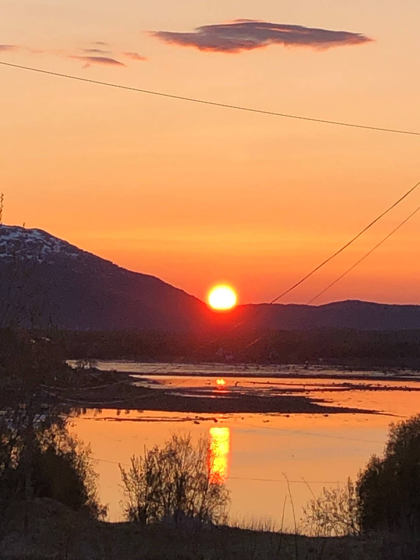 I mai tok Turid Hansen bilde av årets første midnattssol, over et vann på Ørnes. Den speiler seg nærmest som en flamme i vannet.