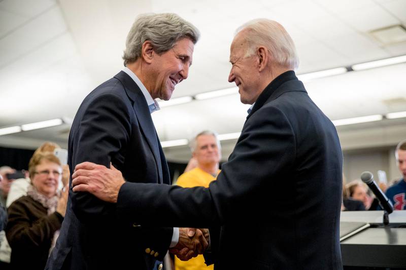 FILE - In this Feb. 1, 2020, file photo Democratic presidential candidate former Vice President Joe Biden smiles as former Secretary of State John Kerry, left, takes the podium to speak at a campaign stop at the South Slope Community Center in North Liberty, Iowa. (AP Photo/Andrew Harnik, File)
