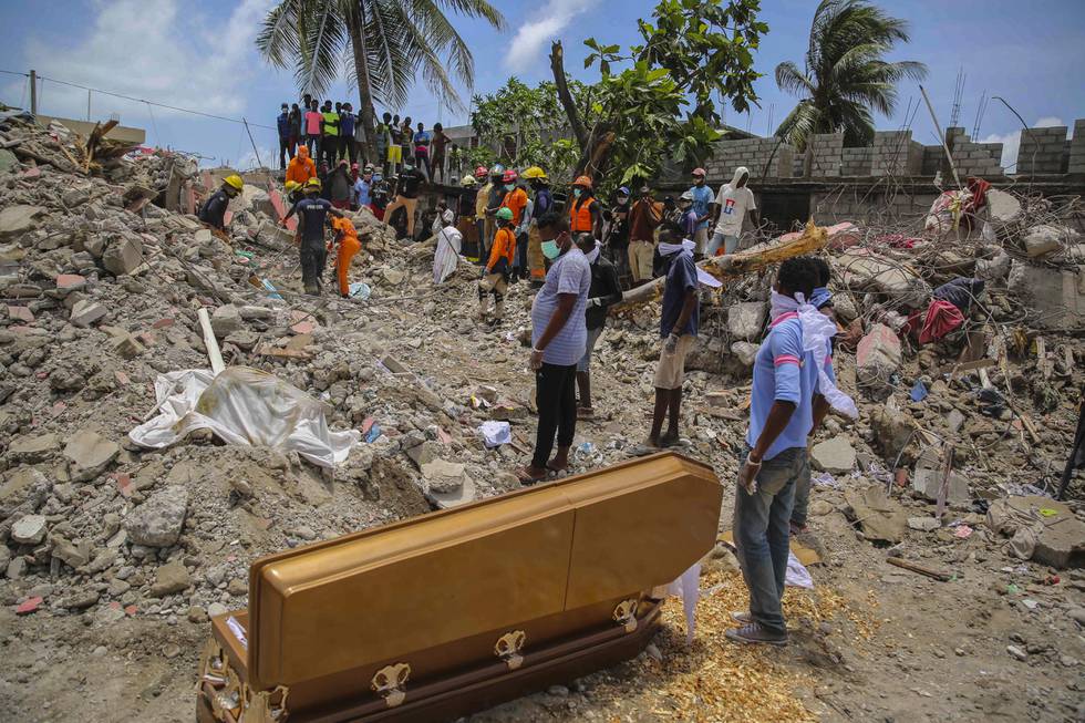 En kiste med en omkommet står oppå ruinene etter jordskjelvet 14. august i Les Cayes, Haiti. Bare dager etter kom en tropisk storm.