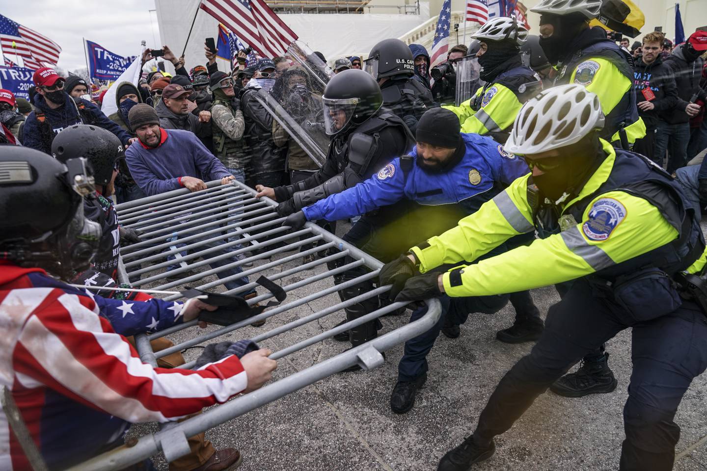 Demonstranter forsøker å bryte seg gjennom gjerdene foran Kongressen 6. januar 2021.