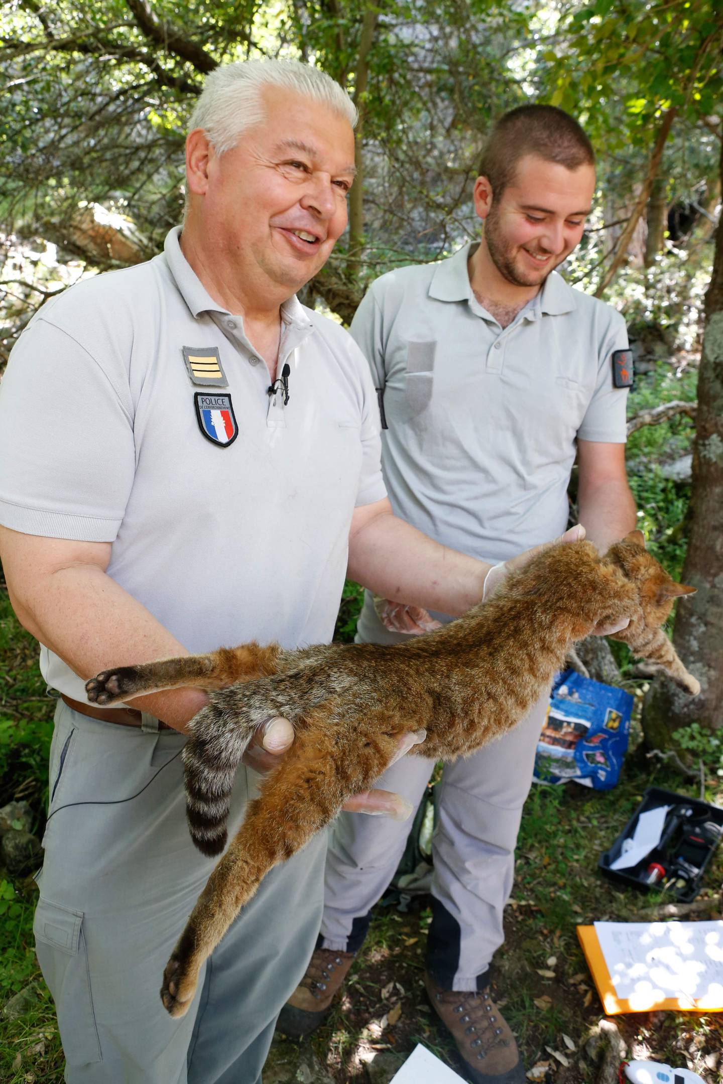 Pierre Benedetti (t.v) and Charles Antoine Cecchini viser fram en katterev som de har fanget for å studere på øya Korsika