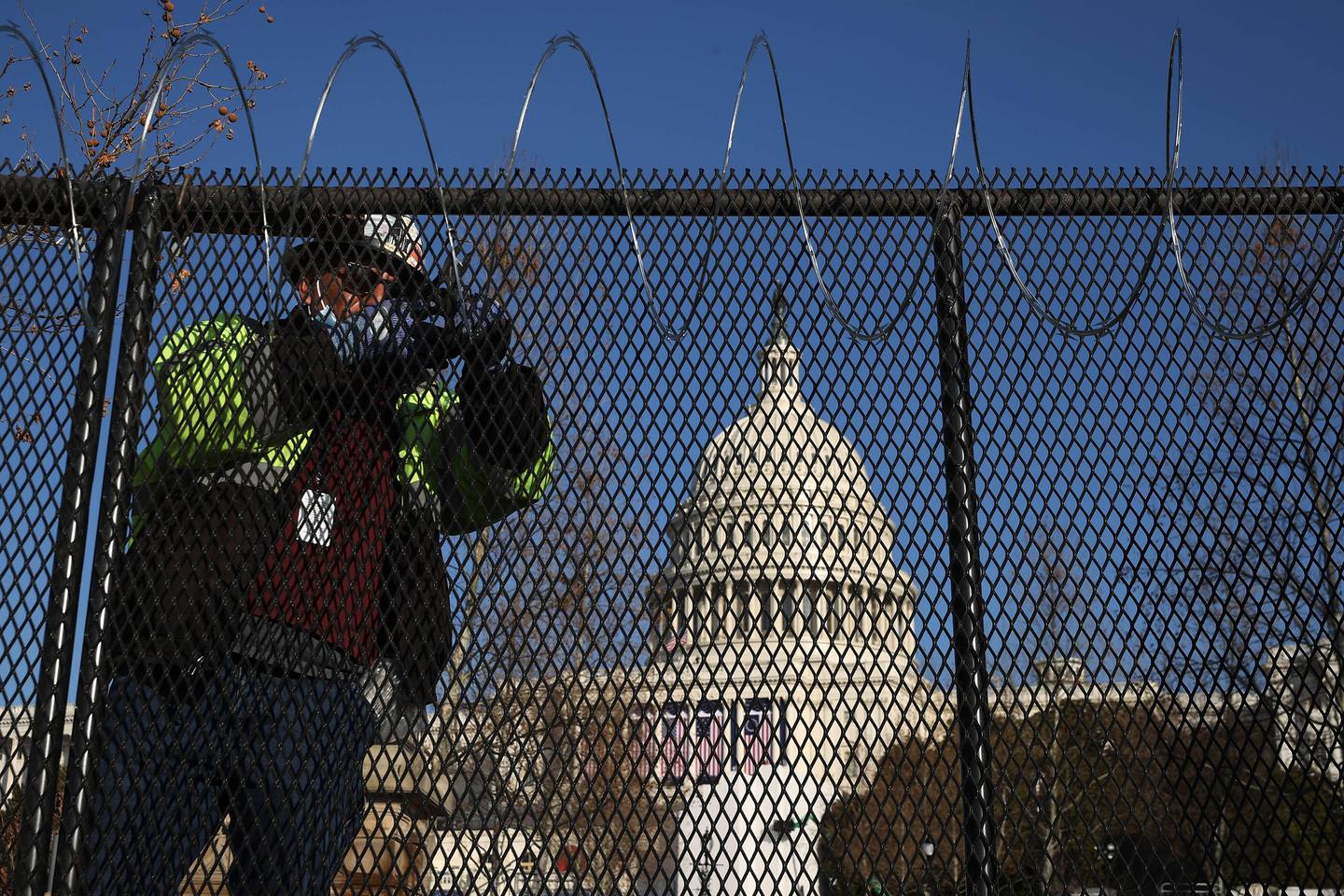 WASHINGTON, DC - JANUARY 14: Workers put concertina razor wire along the top of the 8-foot 'non-scalable' fence that surrounds the U.S. Capitol the day after the House of Representatives voted to impeach President Donald Trump for the second time January 14, 2021 in Washington, DC. Thousands of National Guard troops have been activated to protect the nation's capital against threats surrounding President-elect Joe Biden�s inauguration and to prevent a repeat of last week�s deadly insurrection at the U.S. Capitol.   Chip Somodevilla/Getty Images/AFP
== FOR NEWSPAPERS, INTERNET, TELCOS & TELEVISION USE ONLY ==