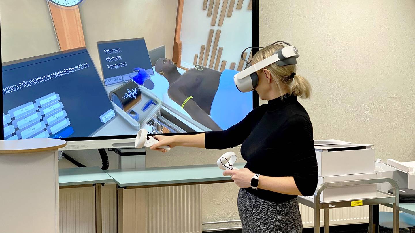 Birgitte Husberg demonstrer hvordan helsestudentene kan øve seg på pasienthåndtering med VR-briller i den virtuelle verden.