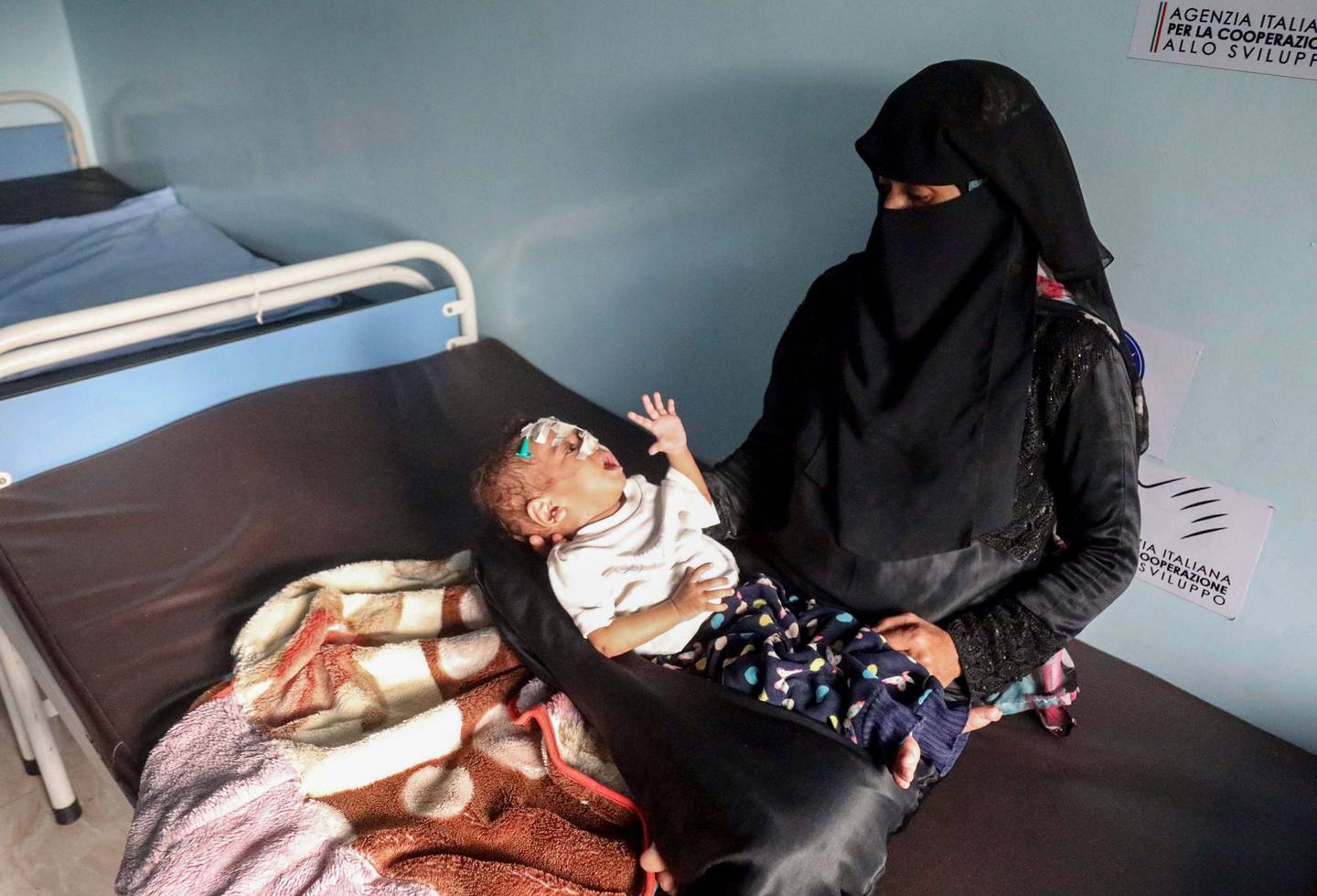 A Yemeni mother comforts her child suffering from malnutrition at a treatment centre in the country's third largest city of Taez, on November 24, 2020. (Photo by AHMAD AL-BASHA / AFP)