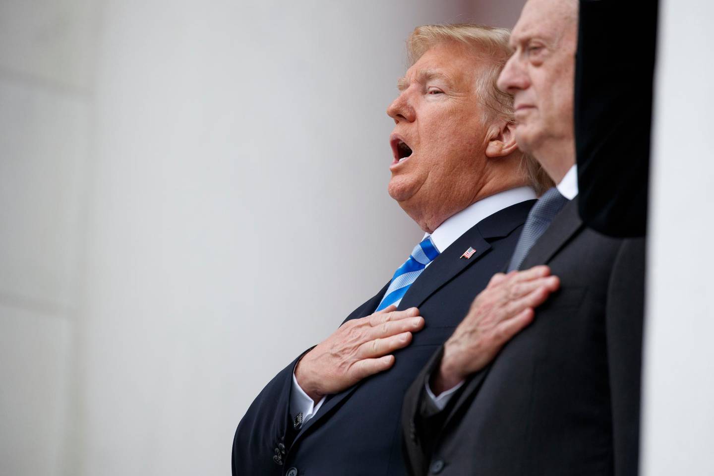 President Donald Trump sings the national anthem during a Memorial Day ceremony at Arlington National Cemetery, Monday, May 28, 2018, in Arlington, Va., with Defense Secretary Jim Mattis/ (AP Photo/Evan Vucci)