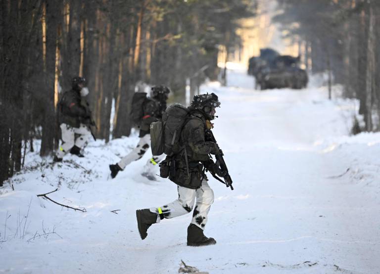 Soldiers of the German armed forces Bundeswehr who are part of the German contingent of NATO's Enhanced Forward Presence, attend exerice in a snow-covered forest on March 7, 2023 near Pabrade, Lithuania, during the visit of the German Defence Minister (unseen). (Photo by Tobias SCHWARZ / AFP)