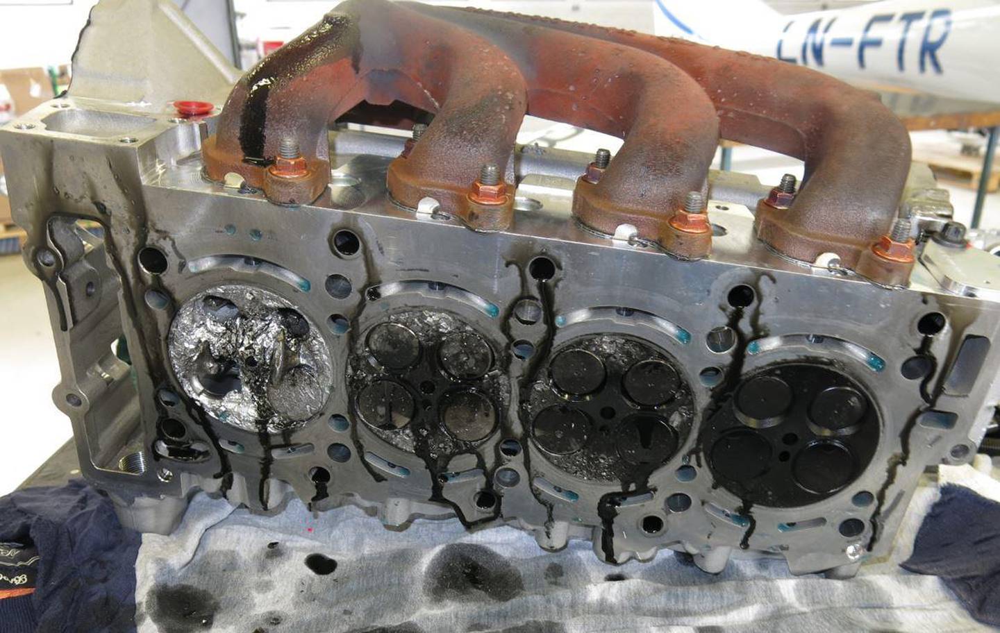 Bildet viser motorens topplokk, som hadde blitt byttet ut dagen før uhellet. Sylindertopp nr. 1 ses lengst til venstre.