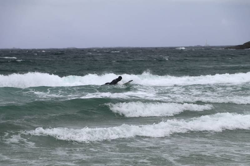 En surfer koser seg i bølgene på Hellestø i helgen. Foto: Arne Birkemo