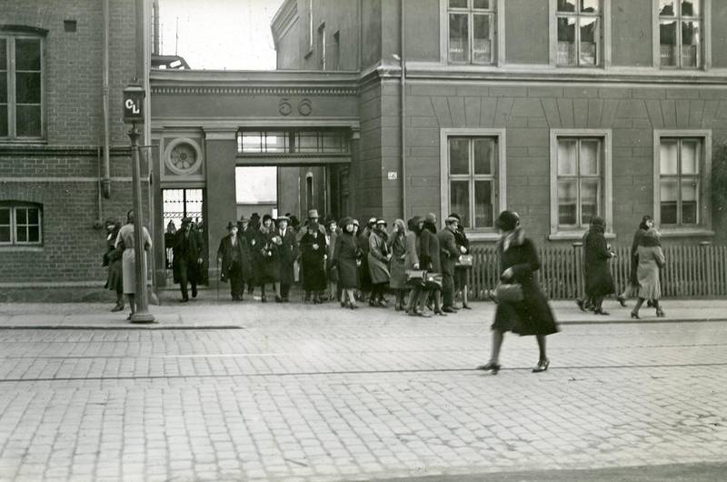 Folk strømmer ut av personalinngangen på Conrad Langaards Tobakkfabrikk i Pilestredet 56 i 1931. Langaard var lenge en av landets største tobakksprodusenter.