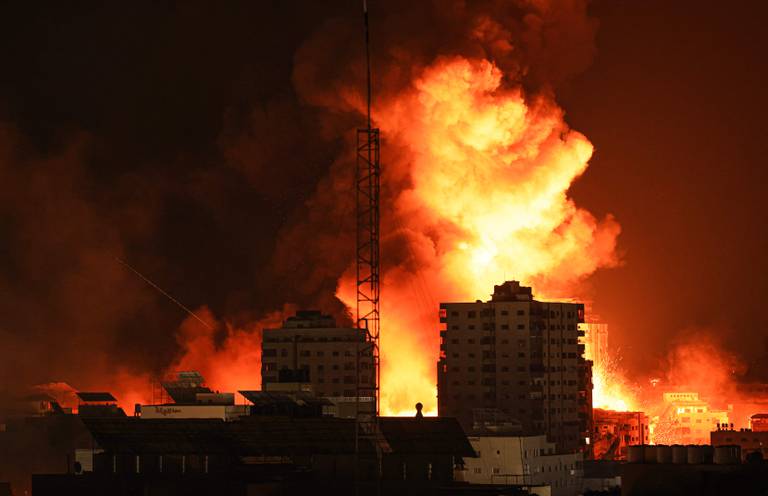 A fireball erupts during Israeli bombardment of Gaza City on October 9, 2023. Israel imposed a total siege on the Gaza Strip on October 9 and cut off the water supply as it kept bombing targets in the crowded Palestinian enclave in response to the Hamas surprise assault it has likened to the 9/11 attacks. (Photo by MAHMUD HAMS / AFP)