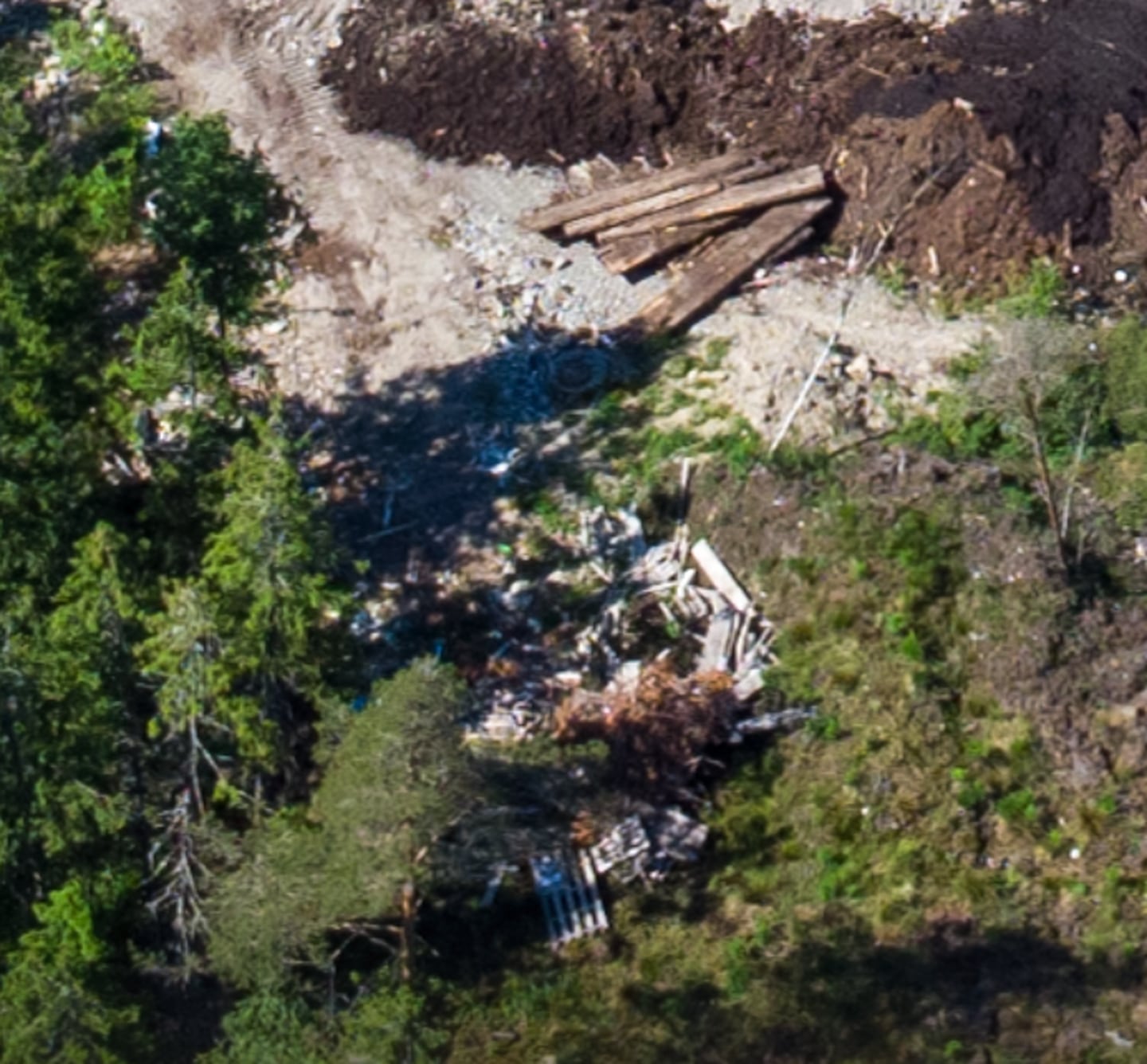 Zoomer man inn på bildet, blir det tydeligere at søppel ligger delvis begravet på tomten på Åkebergmosen.