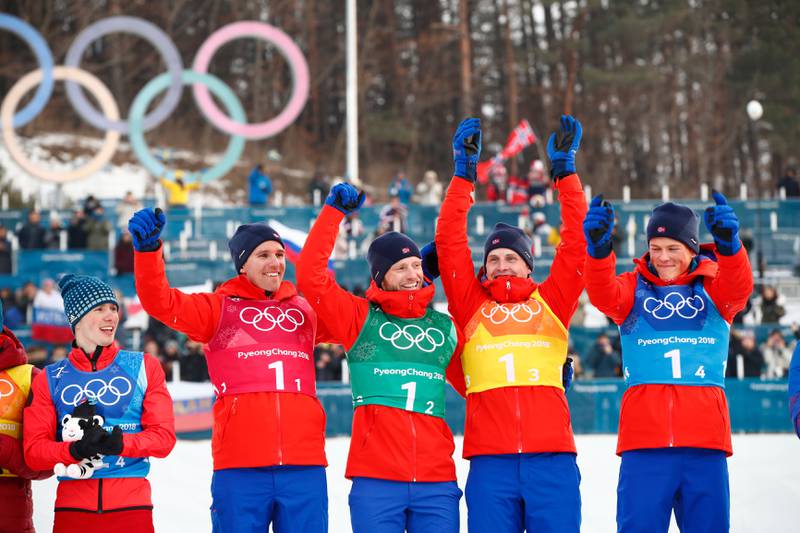 Didrik Tønseth, Martin Johnsrud Sundby, Simen Hegstad Krüger og Johannes Høsflot Klæbo feirer OL-gull på 4x10 km stafett. Til venstre russiske Denis Spitsov.