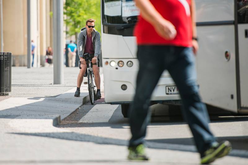 Oslo  20150720.
En mann på sykkel i trafikken blant busser og biler i Bjørvika mandag ettermiddag. 
Foto: Fredrik Varfjell / NTB