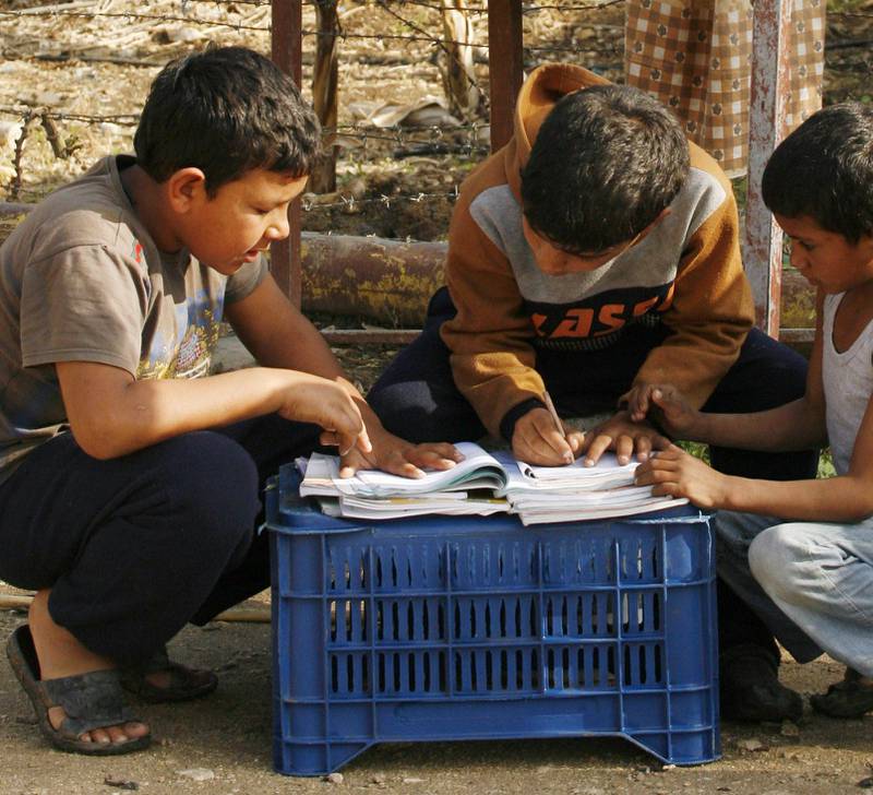 HJEMMESKOLE: Tre gutter gjør lekser i en FN-leir for syriske flyktninger i Libanon. Over 15 millioner barn i Midtøsten går ikke på skole. FOTO: MAHMOUD ZAYYAT/NTB SCANPIX