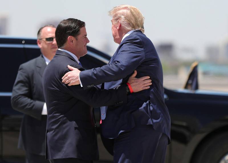 U.S. President Donald Trump hugs Arizona Republican Governor Doug Ducey, as the president arrives at Sky International Airport to tour a nearby Honeywell facility manufacturing protective masks for the coronavirus disease (COVID-19) pandemic in Phoenix, Arizona, U.S., May 5, 2020. REUTERS/Tom Brenner