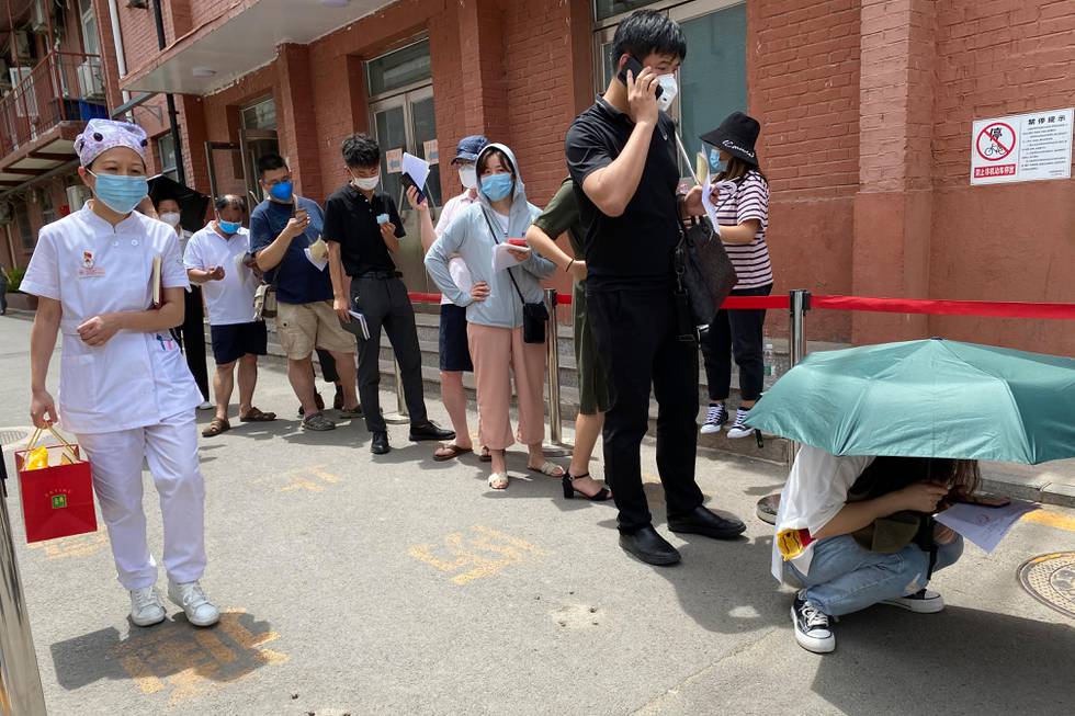 Residents queue up to be tested at a fever clinic in Beijing Monday, June 15, 2020. China's capital was bracing Monday for a resurgence of the coronavirus after more than 100 new cases were reported in recent days in a city that hadn't seen a case of local transmission in more than a month. (AP Photo/Ng Han Guan)
