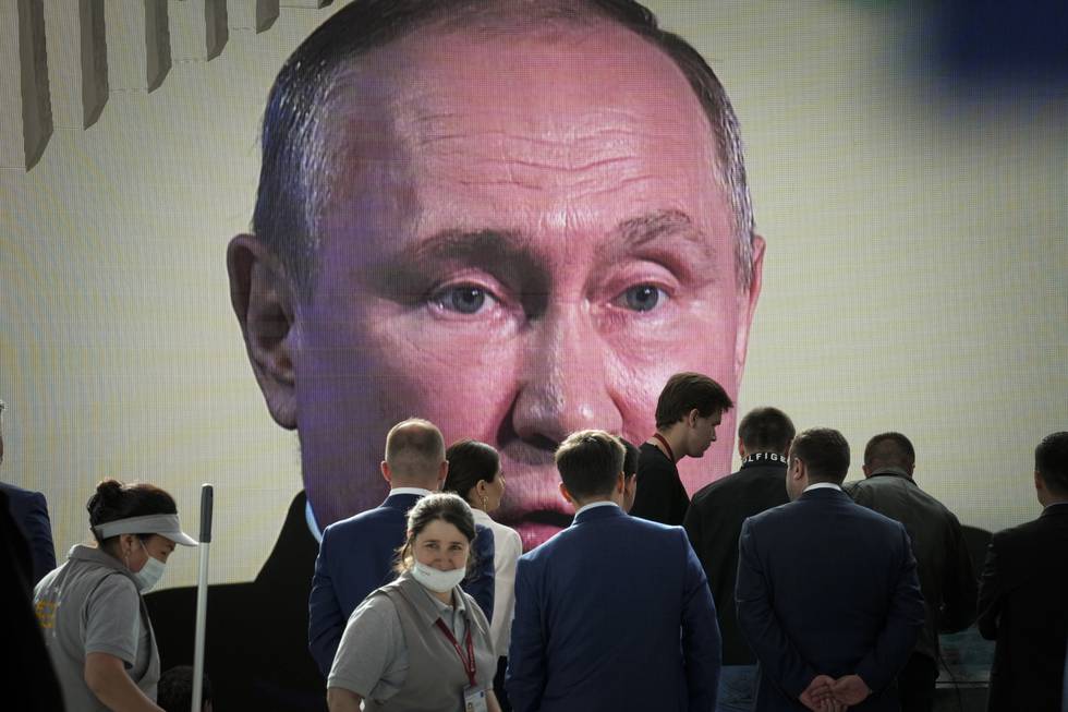 Deltakere på konferansen i St- petersburg ser på mens president Vladimir Putin taler. Foto: Dmitrij Lovetskij / AP / NTB