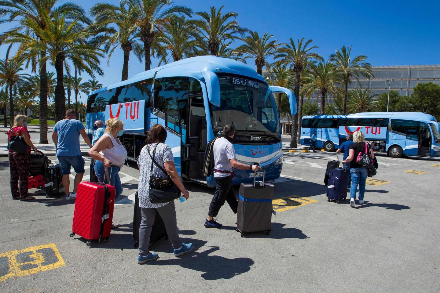 Tourists prepare to board buses upon arrival at the Son Sant Joan airport in Palma de Mallorca on June 22, 2020 as EU member state citizens and those from the passport-free Schengen zone were allowed freely into Spain, with no 14-day quarantines required following a national lockdown to stop the spread of the novel coronavirus. (Photo by JAIME REINA / AFP)