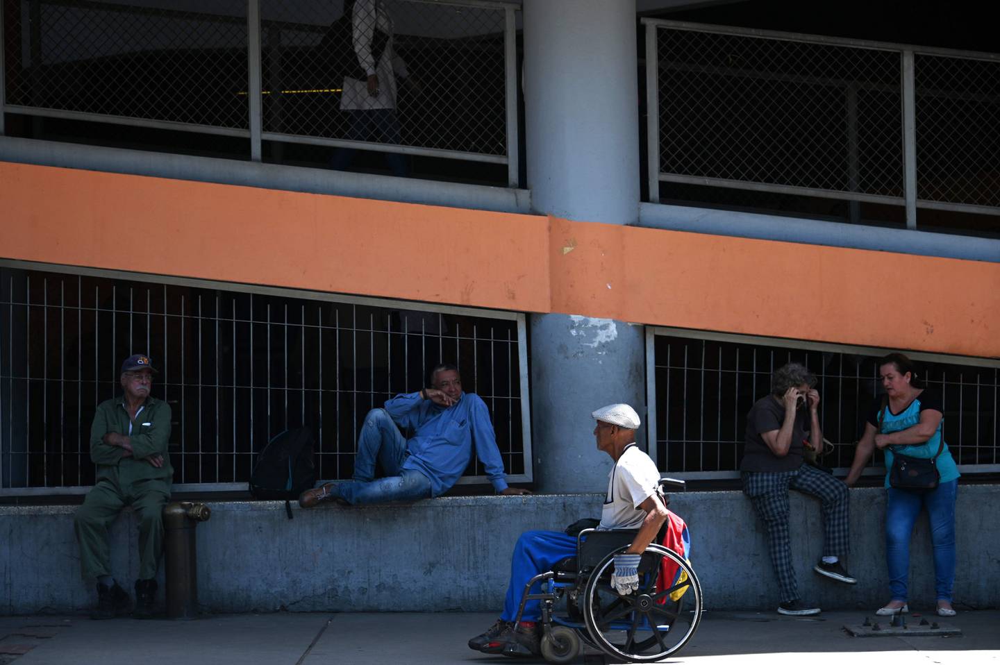 Patients are seen outside the University Hospital in Caracas on May 13, 2019, during a nurses demo. - Members of the Board of Directors of the Nursing School of the capital district demonstrated to make public their critical work situation and to demand Venezuelan President Nicolas Maduro for explanations on the whereabouts of humanitarian aid. (Photo by MARVIN RECINOS / AFP)
