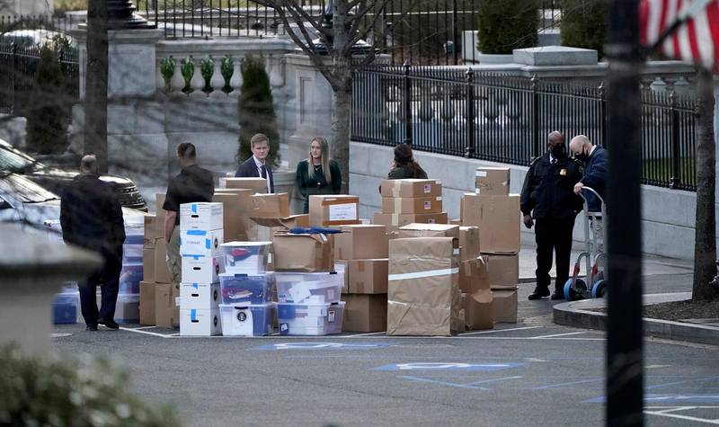 FILE - In this Jan. 14, 2021, file photo people wait for a moving van after boxes were moved out of the Eisenhower Executive Office building inside the White House complex in Washington. The public wont see President Donald Trumps White House records for years, but theres growing concern that they wont be complete, leaving a hole in the history of one of Americas most tumultuous presidencies. (AP Photo/Gerald Herbert, File)