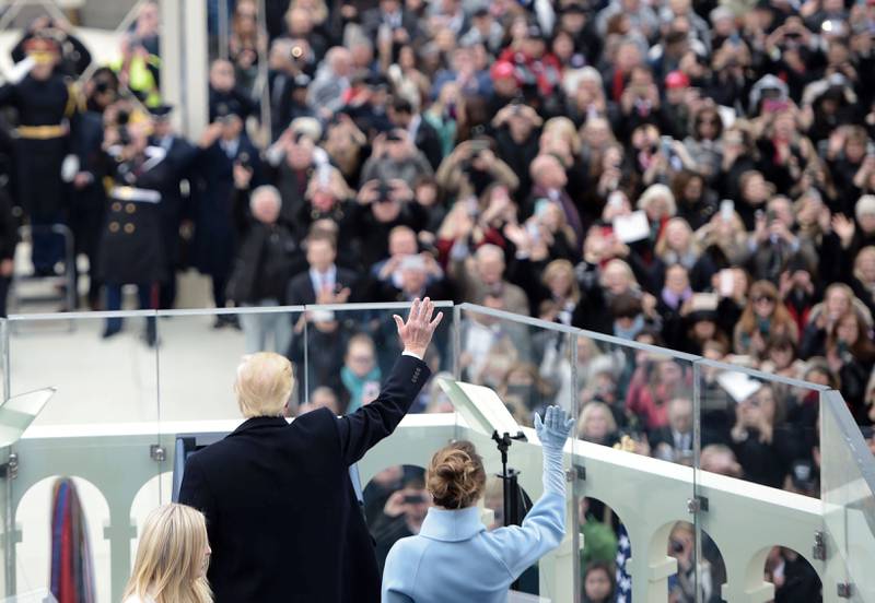 President Donald Trump og kona Melania hilser folket på innsettelseseremonien fredag i Washington DC.