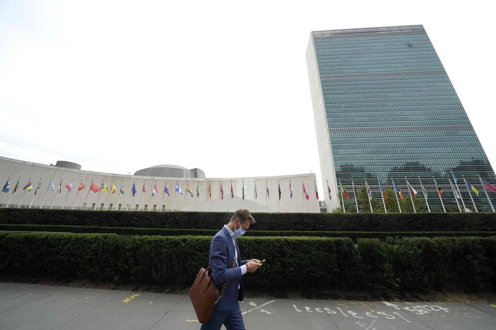 A man passes by the United Nations in New York on September 18, 2020. - During the 75th session of the UN General Assembly, Heads of State and Government will exchange statements via pre-recorded messages, that will be broadcast to a nearly empty General Assembly Hall due to the Covid-19 pandemic. (Photo by TIMOTHY A. CLARY / AFP)