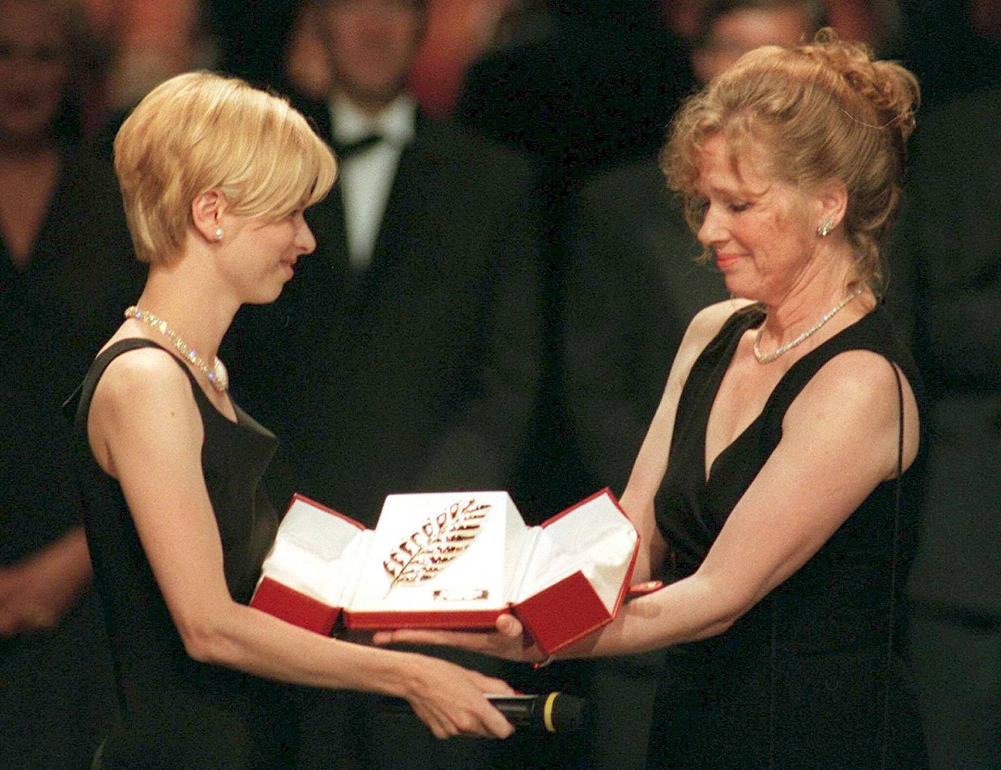 Linn Ullmann, left, receives on behalf of her father, Swedish director Ingmar Bergman the Palm of the Golden Palms from her mother, Norwegian actress Liv Ullmann Sunday May 11, 1997, at the festivals Palace in Cannes. The Cannes film festival is celebrating its 50th anniversary Sunday. (AP PHOTO/Patrick Hertzog/POOL)