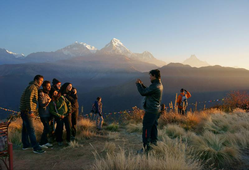 Gruppeklem foran noen av verdens høyeste fjell på Poon Hill. FOTO: CHRISTINE BAGLO