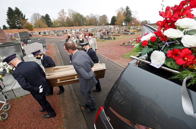 SOS-DECES mortuary employees carry the coffin  of a person who died of the coronavirus disease (COVID-19), during a funeral in Chapelle-Lez-Herlaimont, Belgium November 10, 2020. REUTERS/Yves Herman