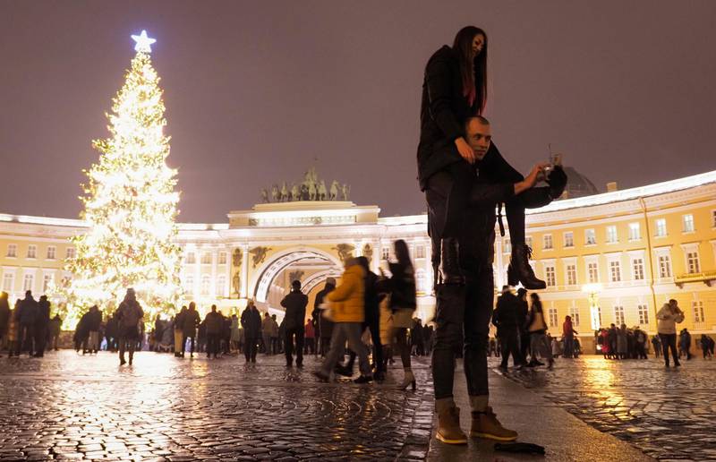 A couple take a selfie photo at the Palace Square during New Year celebration in downtown St. Petersburg, Russia, Friday, Jan. 1, 2021. As the world says goodbye to 2020, there will be countdowns and live performances, but no massed jubilant crowds in traditional gathering spots like the Champs Elysees in Paris and New York City's Times Square this New Year's Eve. The virus that ruined 2020 has led to cancelations of most fireworks displays and public events in favor of made-for-TV-only moments in party spots like London and Rio de Janeiro. (AP Photo/Dmitri Lovetsky)