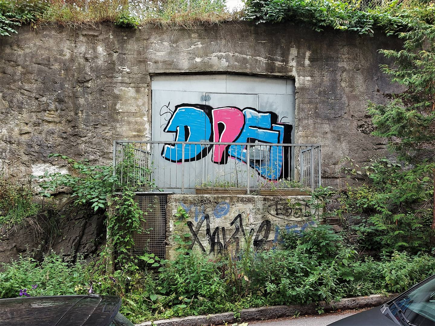 Bilde av en ståldør ved en murvegg dekket med grafitti