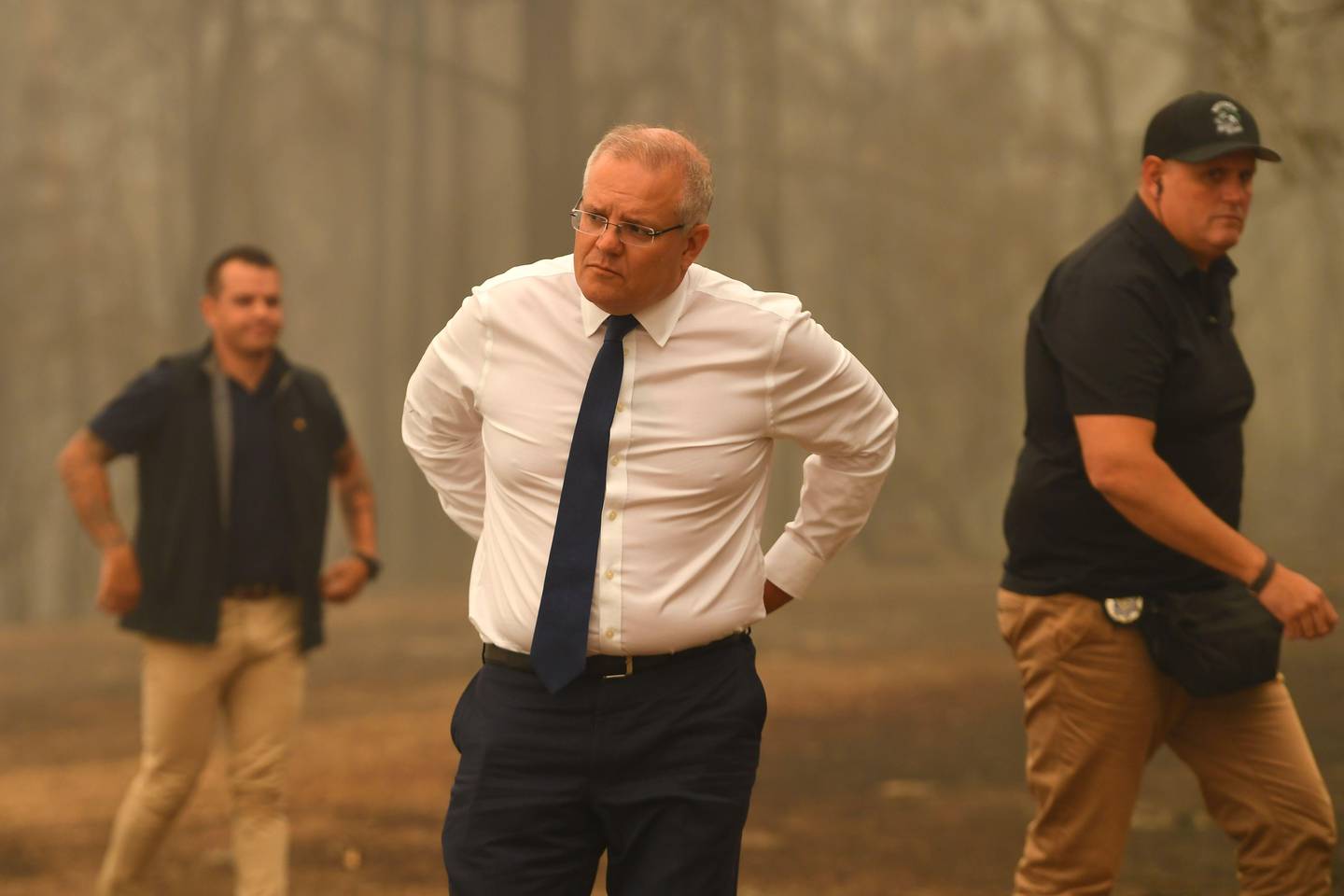 Australia's Prime Minister Scott Morrison (C) visits a resident's property in an area devastated by bushfires in Sarsfield, Victoria state on January 3, 2020. - Australia ordered residents and tourists out of the path of raging bushfires on January 3 as the country braced for a weekend heatwave expected to fan the deadly inferno. (Photo by James ROSS / POOL / AFP)
