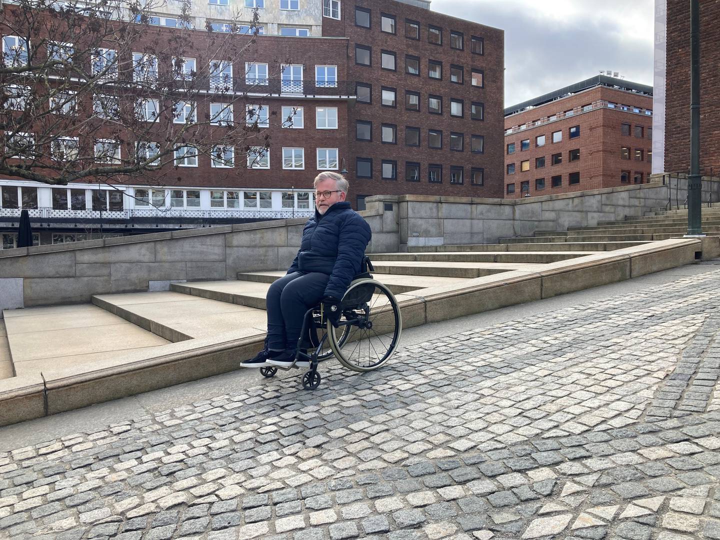 Cato Lie foretrekker å rygge når han skal komme seg opp bakken til hovedinngangen på rådhuset i Oslo fordi den er bratt og brosteinsbelagt. – Da blir det litt mindre slitsomt for en med manuell rullestol, forteller Lie.