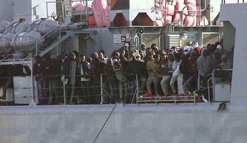 Flyktninger klynger seg sammen om bord i et italiensk marinefartøy på vei inn til Messina lørdag i forrige uke. FOTO: NTB SCANPIX