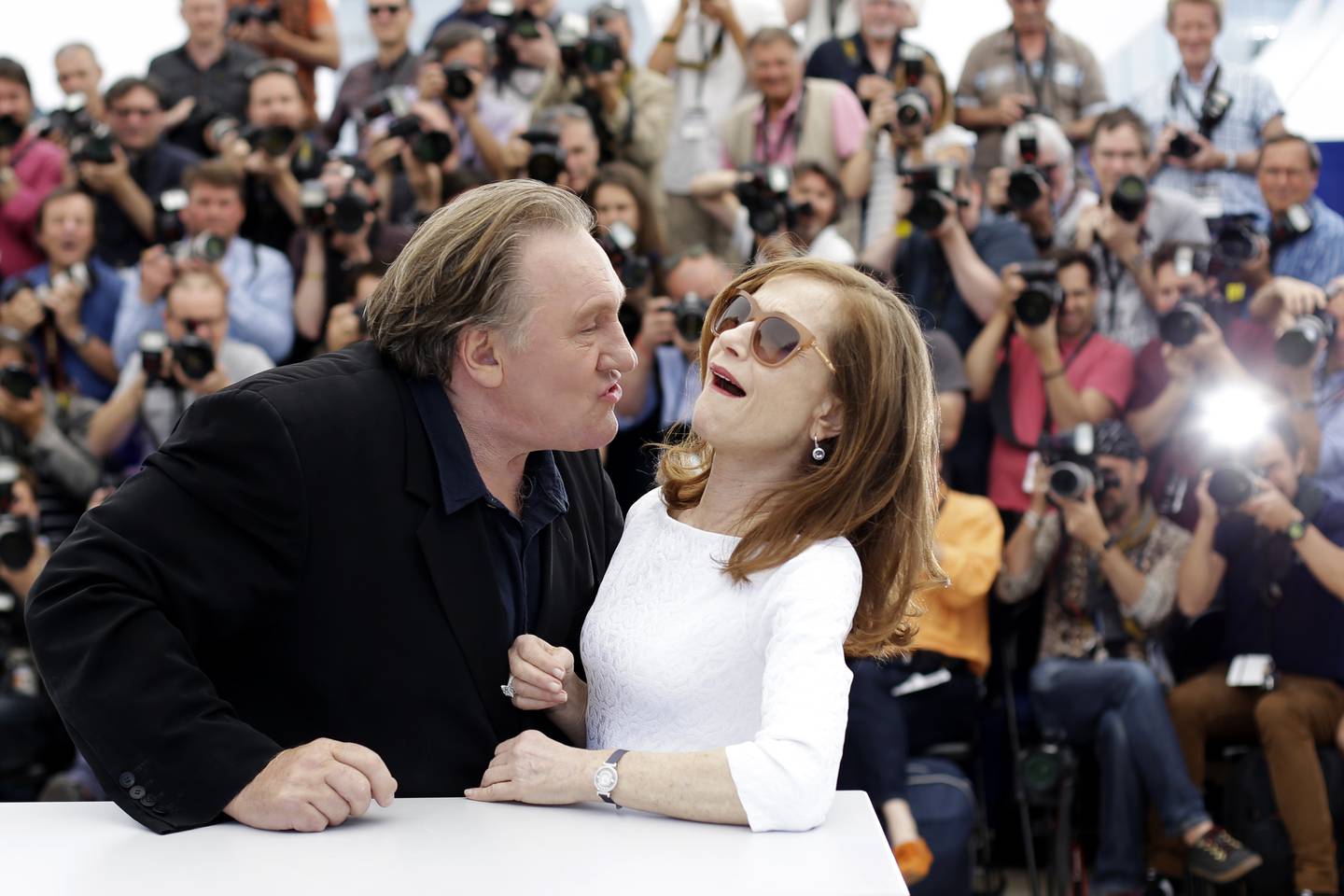 Actor Gerard Depardieu, left, tries to kiss actress Isabelle Huppert during a photo call for the film Valley of Love, at the 68th international film festival, Cannes, southern France, Friday, May 22, 2015. (AP Photo/Thibault Camus)