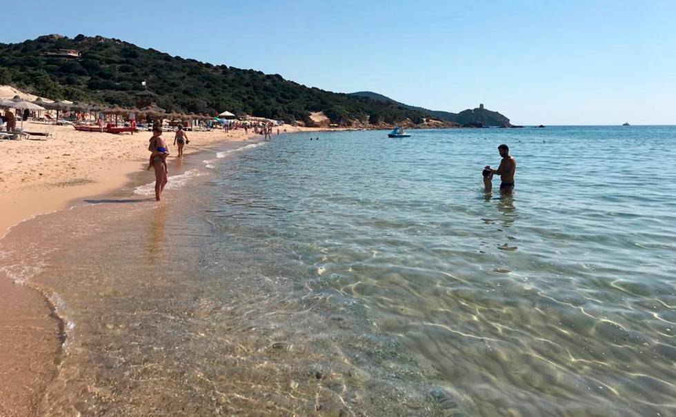 This June 29, 2019 photo made available Tuesday, Aug. 20, 2019 shows people enjoying the white sand and pristine waters of Chia beach, on the Italian island of Sardinia, Italy. A French couple could face up to six years in jail for taking around 40 kg (88.1lbs) of white sand from Chia beach on the Italian island of Sardinia. (AP Photo/Karl A.Ritter)