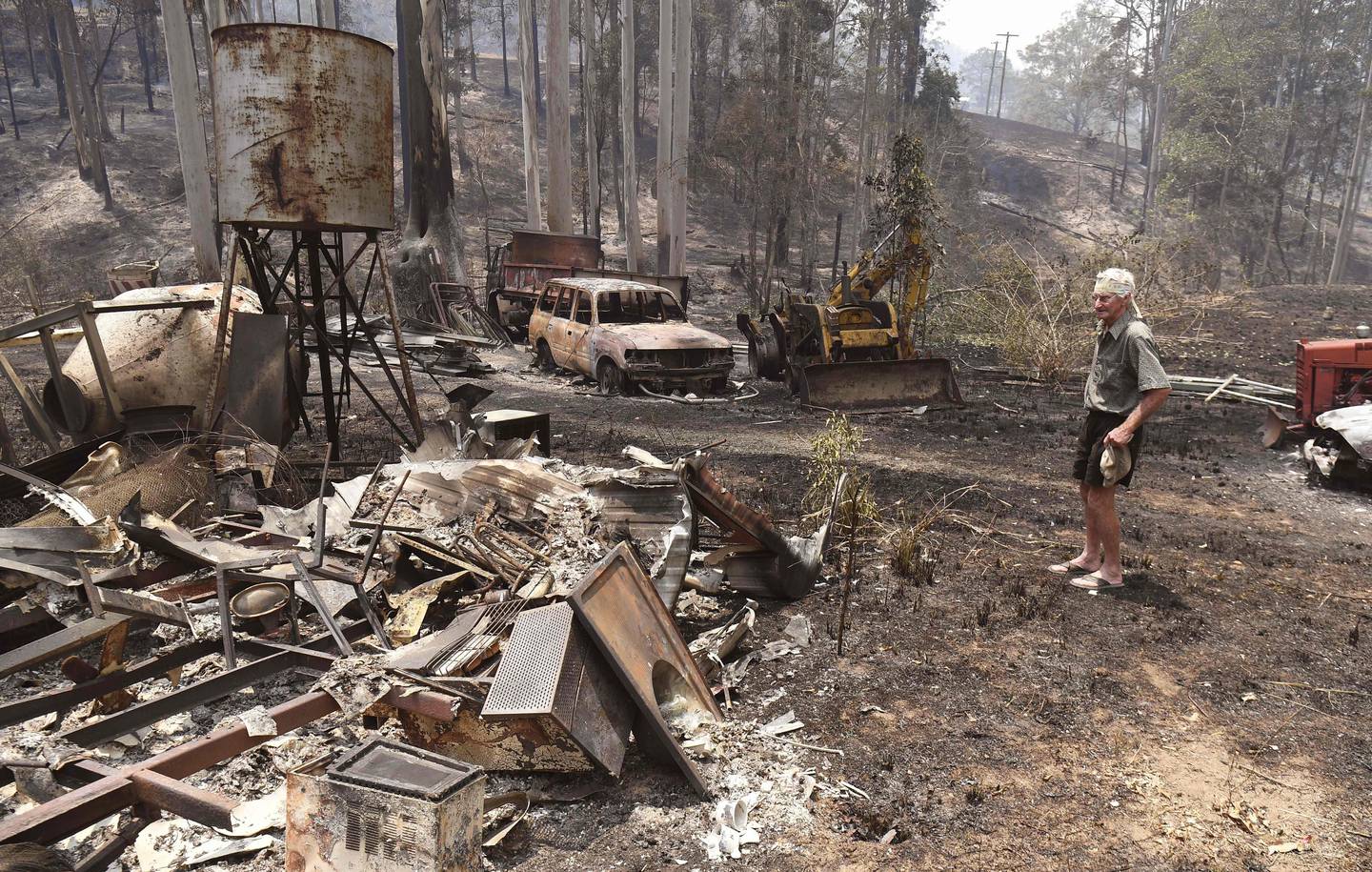 TOPSHOT - Rick Wright inspects the damage next to his house at Nabiac, some 350kms north of Sydney, on November 14, 2019. - The death toll from devastating bushfires in eastern Australia has risen to four after a man's body was discovered in a scorched area of bushland, police said on November 14. (Photo by WILLIAM WEST / AFP)