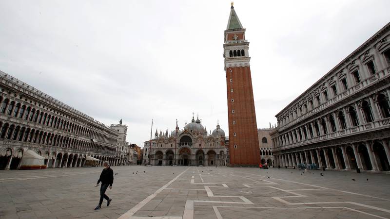 In this picture taken on Wednesday, May 13, 2020, a man wearing a sanitary mask walks in St. Mark's Square in Venice, Italy. Venetians are rethinking their city in the quiet brought by the coronavirus pandemic. For years, the unbridled success of Venice's tourism industry threatened to ruin the things that made it an attractive destination to begin with. Now the pandemic has ground to a halt Italys most-visited city, stopped the flow of 3 billion euros in annual tourism-related revenue and devastated the city's economy. (AP Photo/Antonio Calanni)