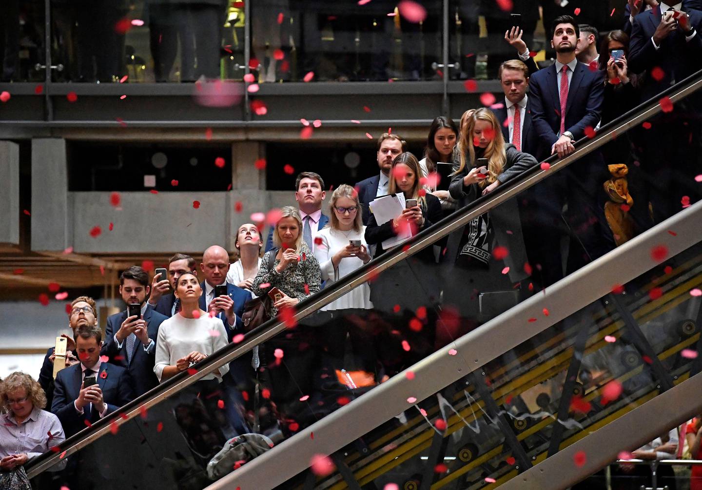 Workers stand for a poppy drop during a Remembrance Service at the Lloyd's building in the City of London, Britain, November 9, 2018. REUTERS/Toby Melville
